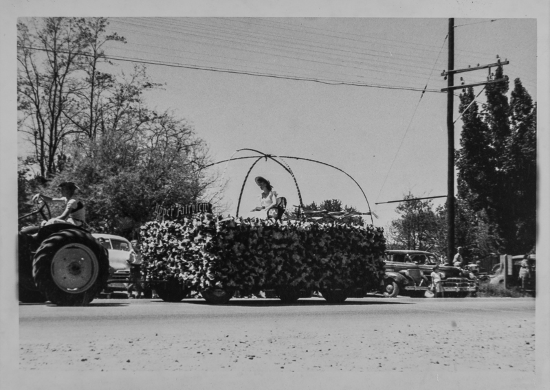 Float with a young woman with a sign "Upper Fairview" being driven by a tractor.