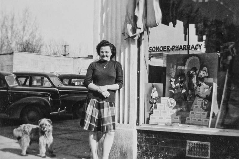 Young woman outside storefront with dog