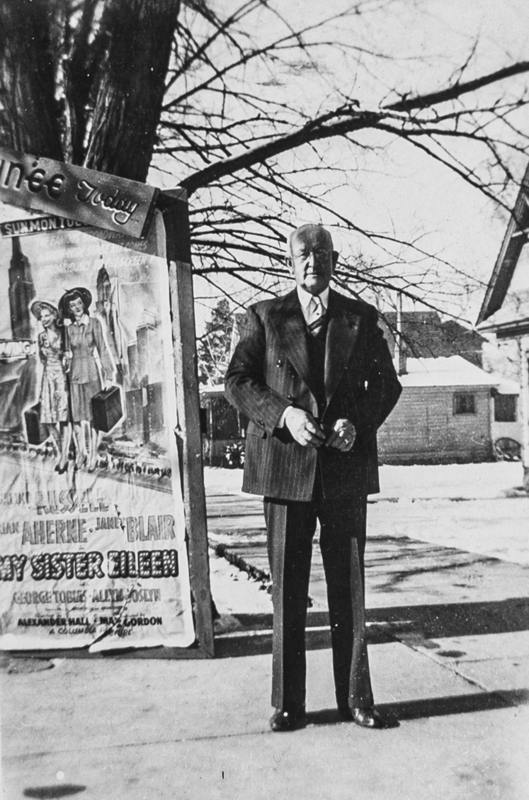 Mr. Matthews posing by a movie poster.