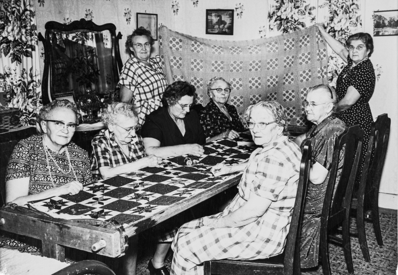 Another copy of the ladies working on a quilt.