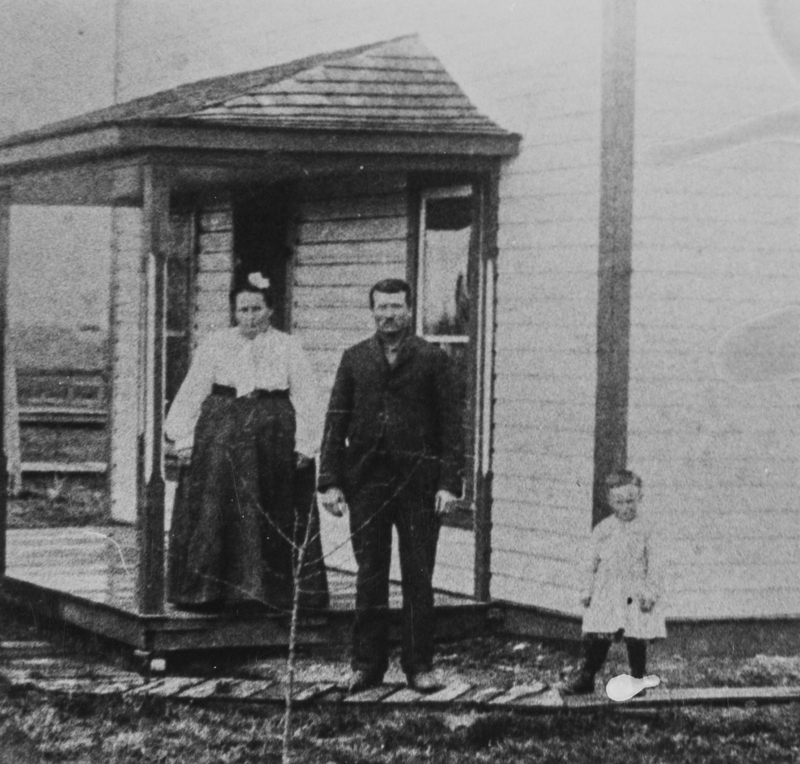 Amos Whiteley as a child with his parents outside their home