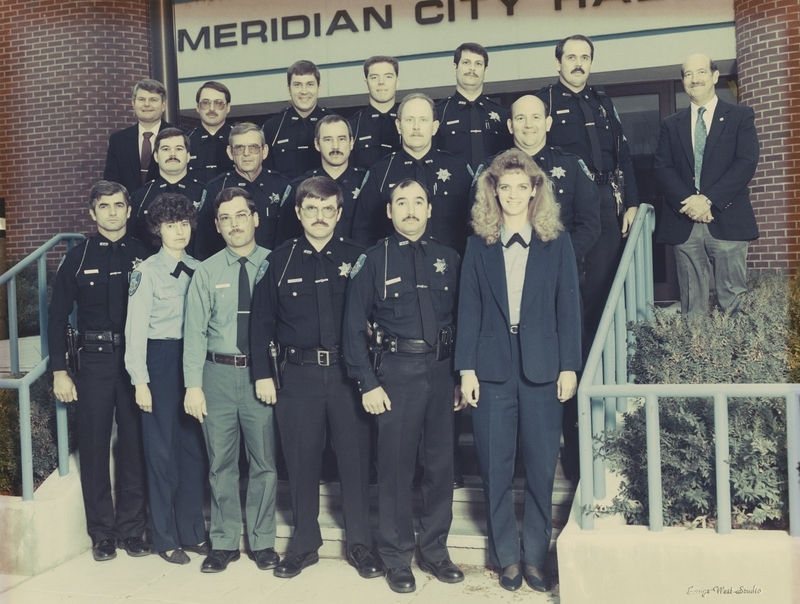 Meridian Police Department Staff on the steps of former Meridian City Hall Building. Back Row: Bob Giesler, Dough Weast, John Overton, Steve Boling, Bill Musser, Kevin Robertson, Chief Bill Gordon; Middle Row: Rick Murphy, Norm Williams, Jerry Payne, Steve Bradley, Dwight Hosford; Front Row: Gene Trakel, Jean Moore, Richard Donahue, Gary Cushman, Paul Carrera, Candy Tipton. Photo from 1990. 