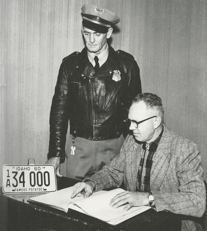 Police Chief Steve McGill and Harold Cox look over records, circa 1959