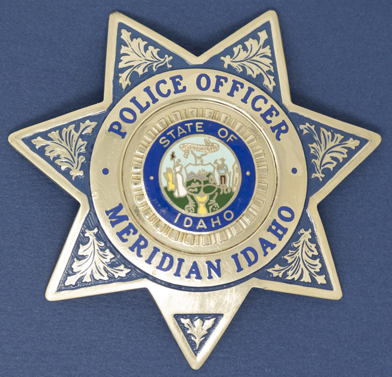 Meridian Patrolman Badge (Blue Star with floral silver)-this style of badge can be seen in this collection's black and white photo of Police Chief Bill Gordon. The badge's information is undated, but perhaps the late 1980s or early 1990s could be its age. 