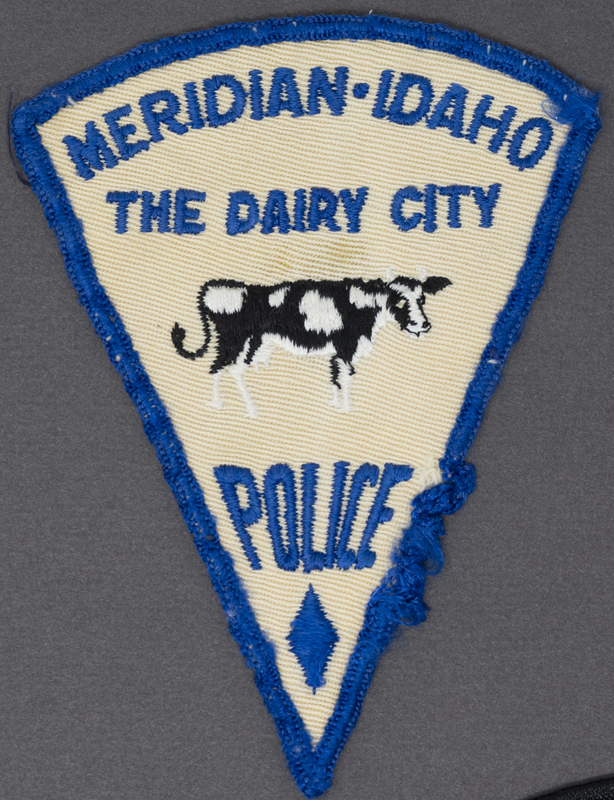 Meridian Police "The Dairy City" Patch (First Patch) was released about the early 1960s. Apparently many people interpreted wrong ideas about the cow tail facing upward and became offended. The patch eventually became replaced with one in which the cow tail pointed straight down. The version of the cow tail up came in both white and a second issued light orange. Not only was the cow symbolic of the dairy center, but the shape of the patch looked like a wedge of cheese. All Meridian Police Dairy patches were dropped in the late 1970s or early 1980s. 