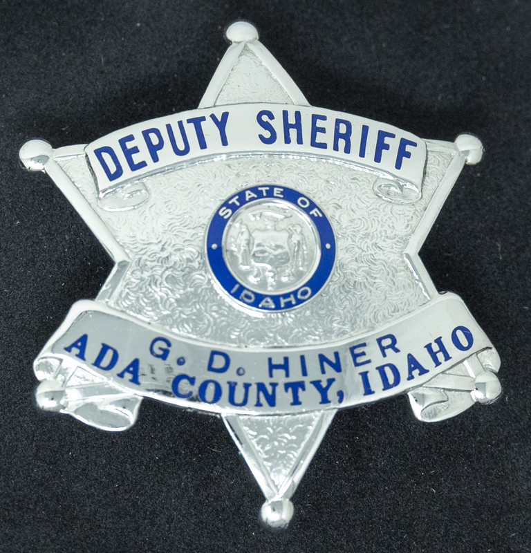 Gene Hiner Deputy Sheriff badge. Hiner served as a Deputy in the Ada County Sheriff's office in 1958. Part of the Gene Hiner Police Career Display presented to the MPD by Gene Hiner's family.