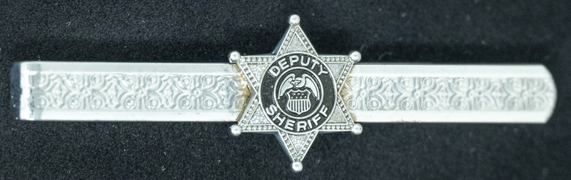 Gene Hiner Deputy Sheriff tie clip, from Hiner's time as a Deputy Sheriff in 1958. Part of the Gene Hiner Police Career Display presented to the MPD by Gene Hiner's family. 