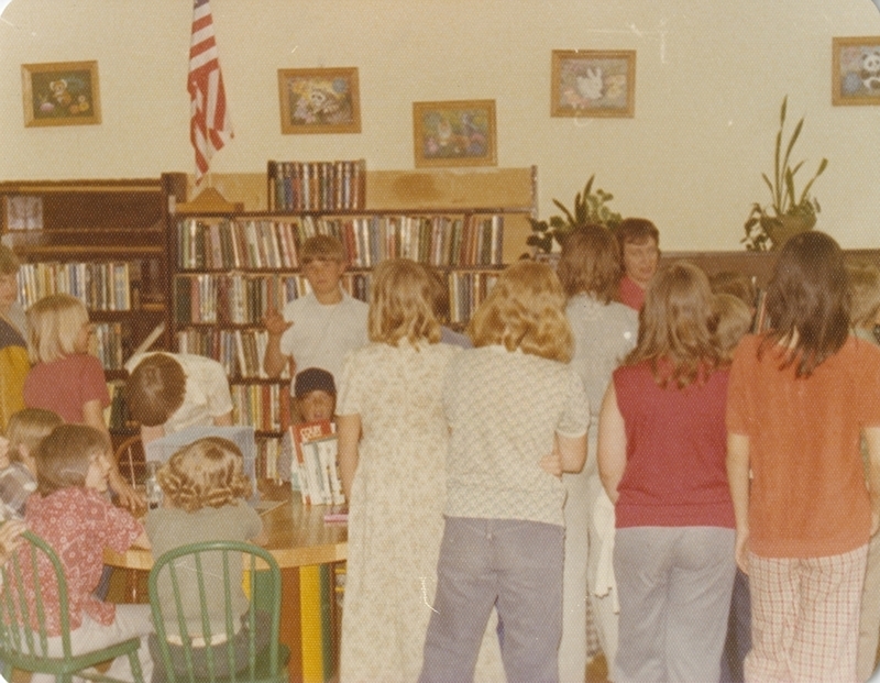 Librarian helps welcome a Meridian school class to the library on a field trip. 