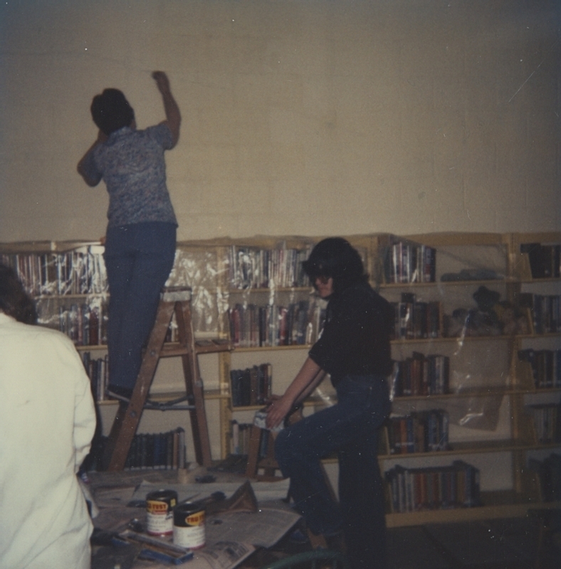 Individuals gather to help create a mural for the Meridian Library wall