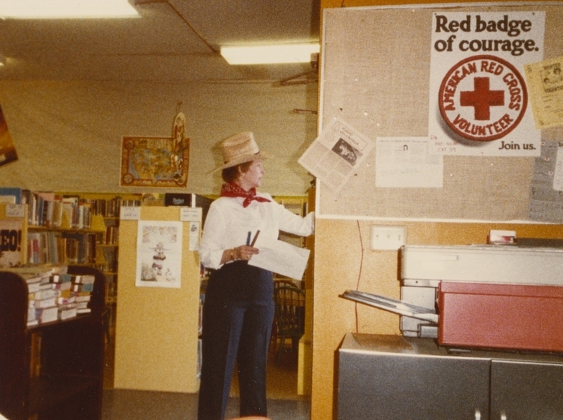 Librarian Gaye Walter hangs up decorations for the library's Wetsern reading theme. 