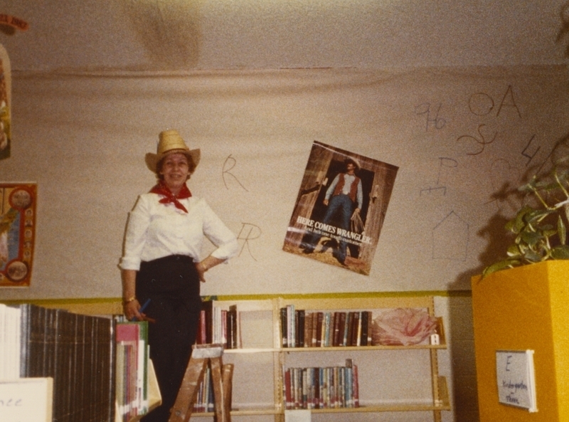 Librarian Gaye Walter helps hang decorations for the library's Western theme. 