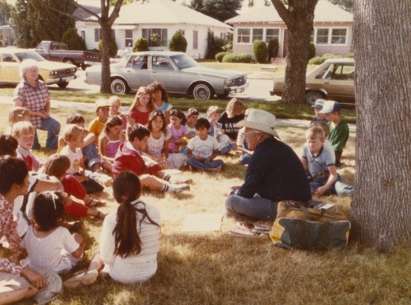 T.H. Bird, a retired rodeo announcer, talks with children at a library event.