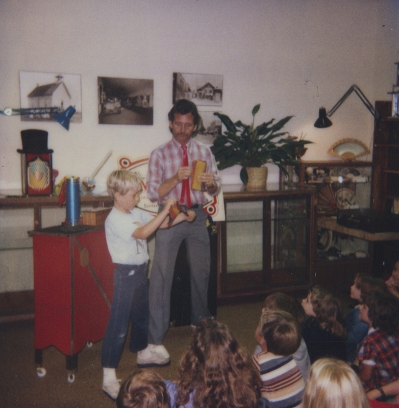 Audience member Clark assists The Great Moodini during a Meridian Library event.