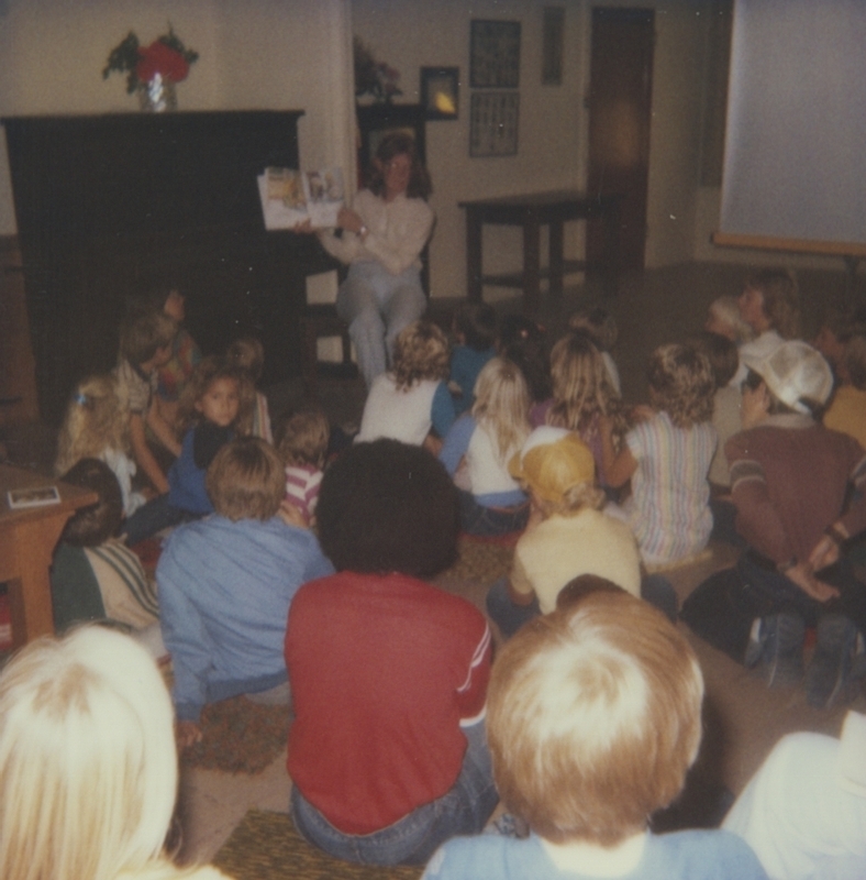 Librarian reads to children as part of the smokejumper event. 