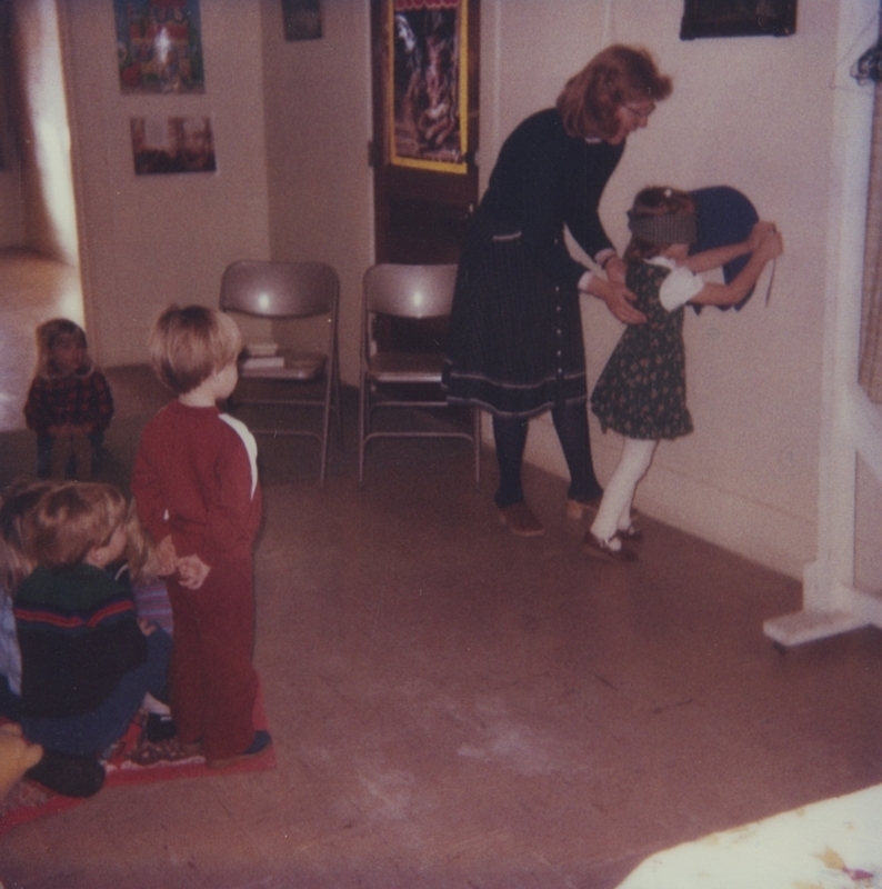 Children watch on as a girl takes her tunr during an activity of Pin-The-Tail on the Donkey.