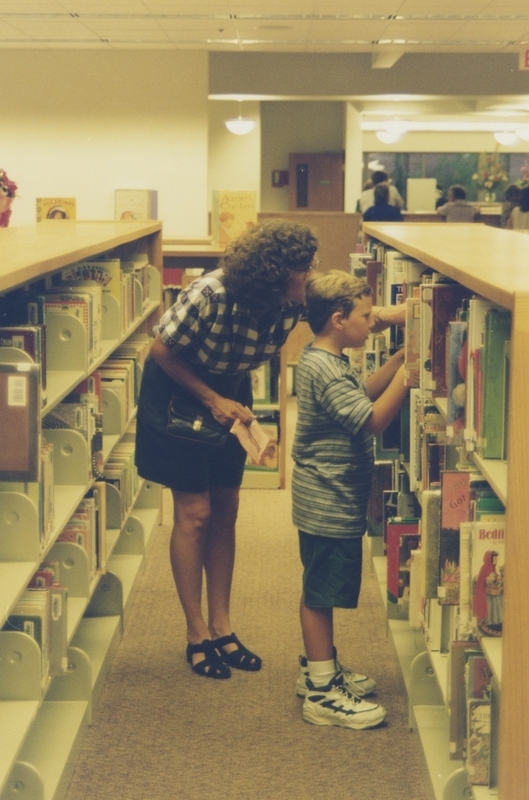 A woman and child browsing children's books at the Cherry Lane Library open house. 