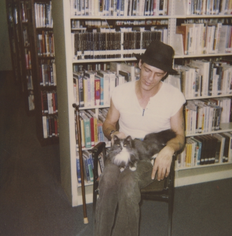 Meridian Library's gray and white cat sits in a patron's lap in April 1990. 