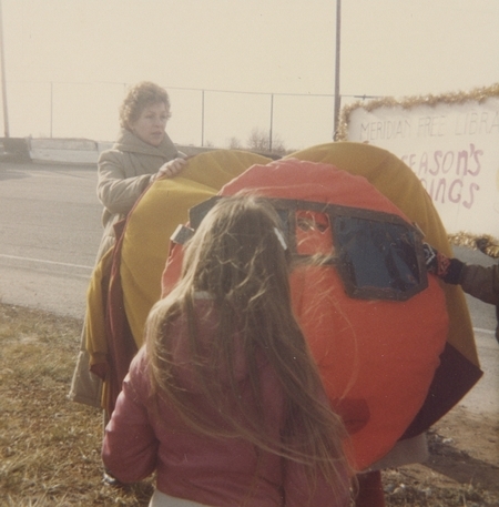 Library parade walkers prepare the giant bookworm for the Holiday Parade. 