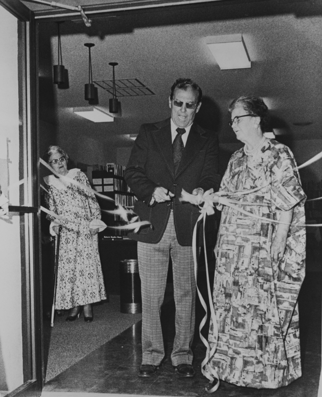 Black and White photo of the June 1, 1974 opening of the newly enlarged Meridian Library. In the forefront stands Meridian Mayor Don Storey, and librarian Nancy Sage.