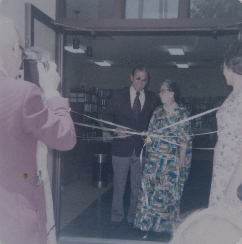 Color photo of the June 1, 1974 opening of the newly enlarged Meridian Library. Near the ribbon stands Meridian Mayor Don Storey, and librarian Nancy Sage.